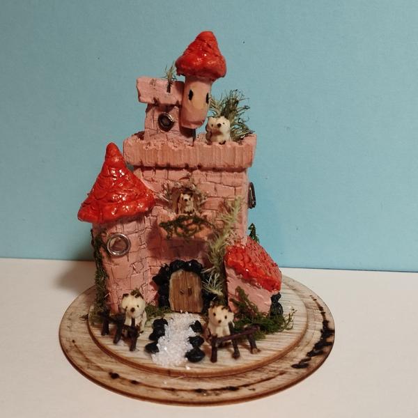 Petite maquette de château roseLe château est habité par de renards. Les toits des tours sont rouges. De la mousse pousse sur les murs.