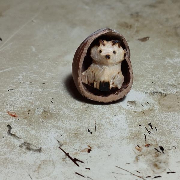Un renard en bois dans une demi noisette 