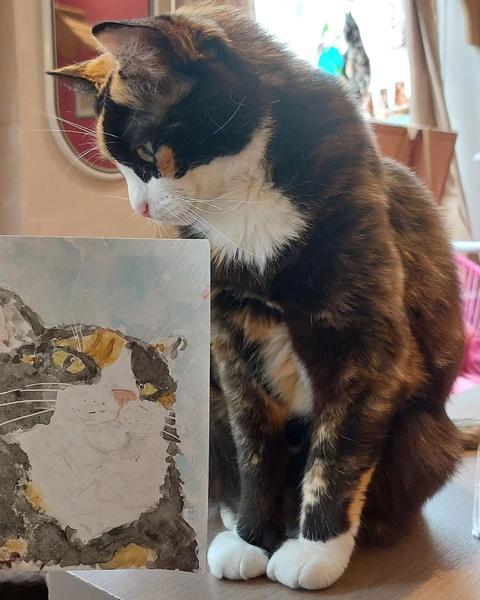 Nola qui regarde son portrait. Elle semble intéressée
