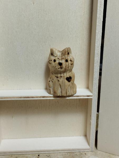 Un chat en bois, avec une tâche en forme de cœur