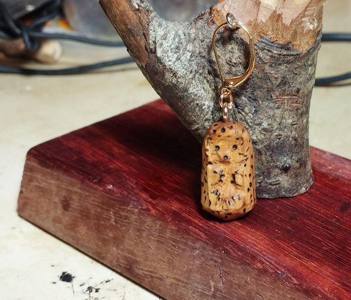 Un pendentif hérisson en bois. Les piquants sont pyrogravés