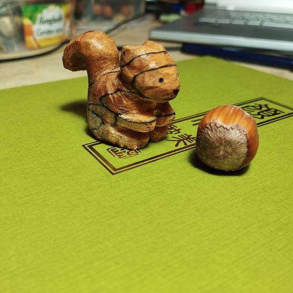 Sculpture d'écureuil à côté d'une noisette 