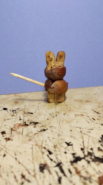 Un petit lapin chevalier en bois. Armé d'une épée, il est protégé par un casque et un bouclier
