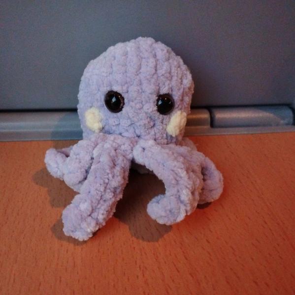 Un poulpe au crochet. Couleur violette avec des pomettes jaunes. Les yeux en plastique le rendent mignon 