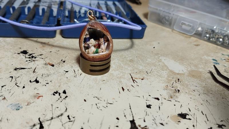 Un pendentif noisette, avec une petite scène dans la noisette 