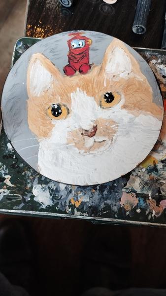 un portrait d'un chat roux et blanc avec un petit nono, robot rouge d'ulysse 31 posé sur sa tête