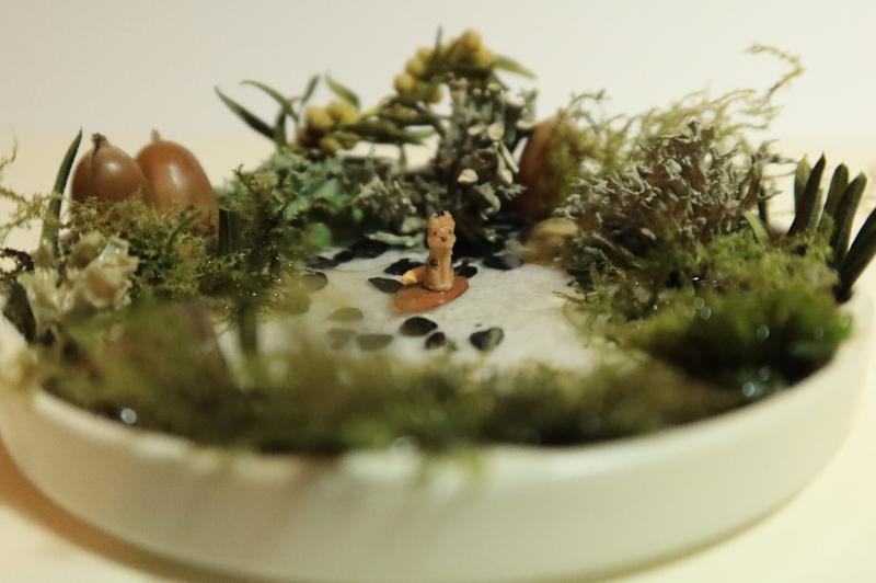 petite sculpture de chien posée sur une feuille dans un décor de mare