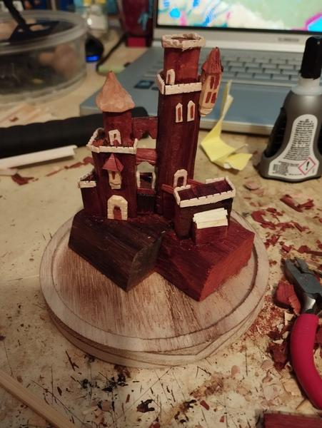 Une maquette de château en bous rouge