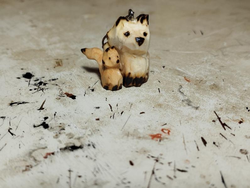 Deux petits renards en bois. Le plus grand à l'air triste, le plus petit se demande ce qu'il fait là 