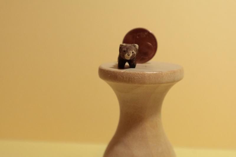 mini sculpture de panda roux devant une pièce de 1 centime