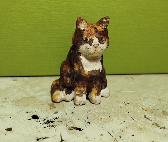 Une sculpture en bois de chatte tricolore