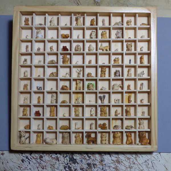 Photo d'un cadre en bois avec une grille 10 x 10 rempli de mini animaux en bois.Beaucoup de renards, des chats, des hérissons, des grenouilles, quelques oiseaux, des souris et d'autres animaux