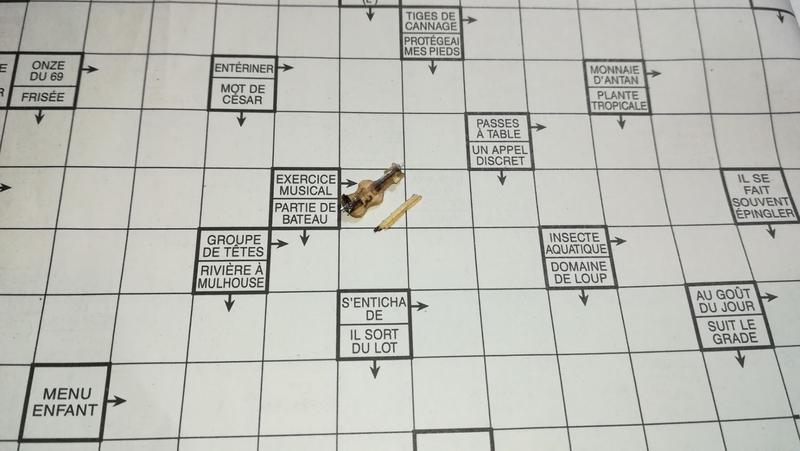 Mini violon en bois posé sur une case de mots fléchés à côté de la définition "exercice musical" 