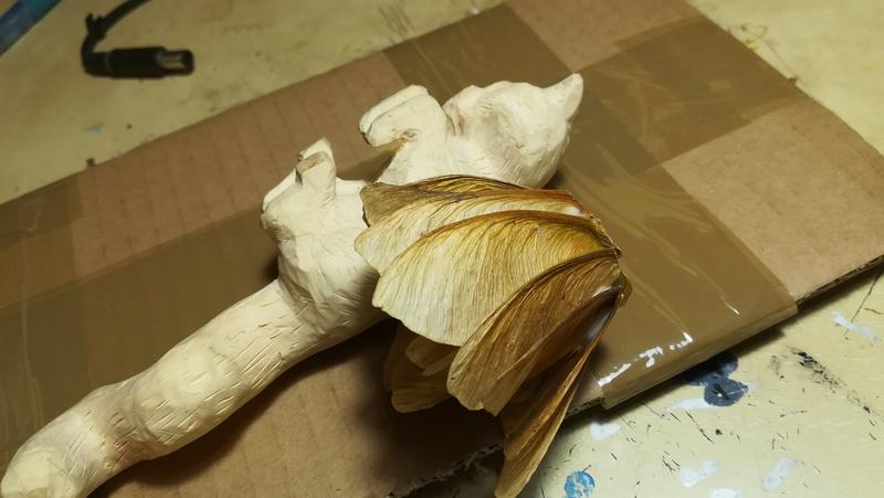 sculpture de chat avec une aile faite avec des fruits d'érable, vue de profil