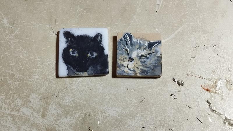 Deux petits portraits de chats : un tout noir et un gris / tigré 