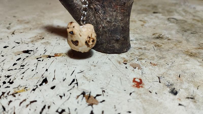 Un petite poule en bois. Un coeur est pyrogravé sur son torse