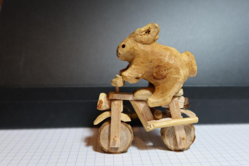 Sculpture en bois d'un lapin sur une moto 