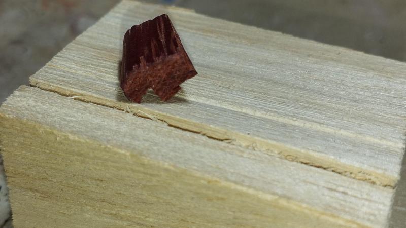 Un petit morceau de bois dont la forme rappelle la silhouette d'un ours de profil