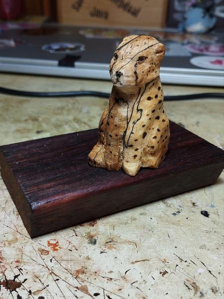 Sculpture d'un guépard en bois, assis