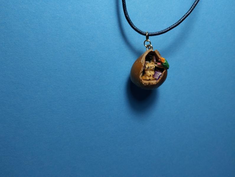 Un pendentif noisette avec un rat et un perroquet 