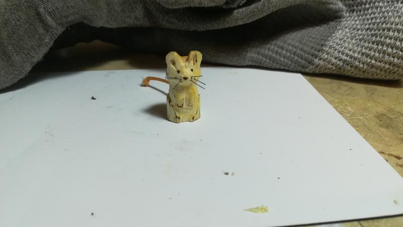 Petite sculpture de souris en bois. Avec des moustaches en nylon noir et une queue orange en lacet 