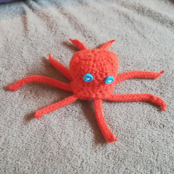 Un poulpe rouge fait au créé, avec des boutons bleus pour les yeux 