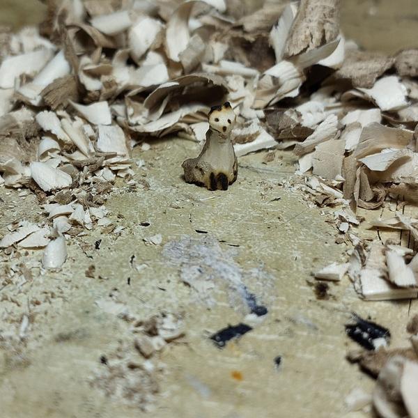 Un mini renard en bois devant des copeaux