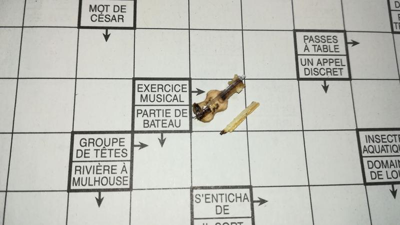Mini violon en bois posé sur une case de mots fléchés à côté de la définition "exercice musical" 