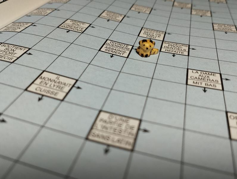 Une mini sculpture de renard posée sur une case de mots fléchés 
