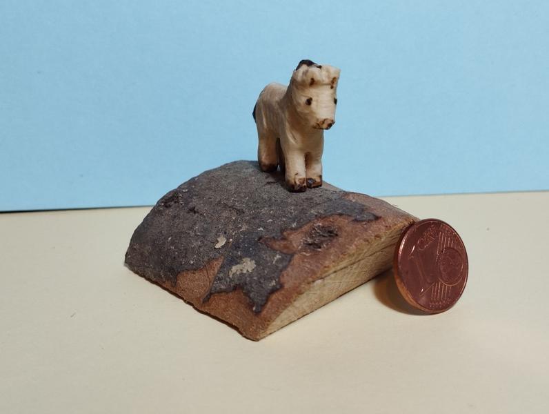 Le cheval vu de face. Une pièce d'un centime est posée à côté du socle. Le garrot est à peu près aussi haut que la pièce 