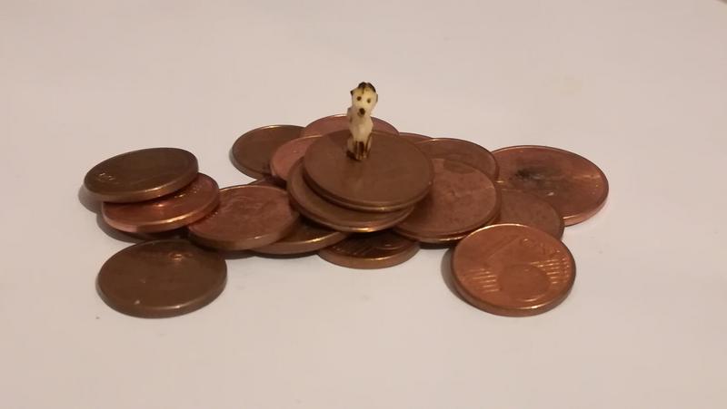 mini sculpture de renard sur un tas de pièces