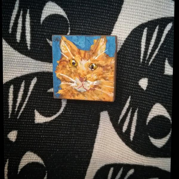 Mini portrait de main coon roux qui louche sur carré de mosaïque 