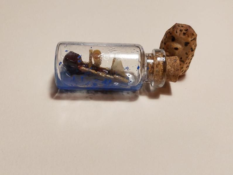 Un petit bateau en bois dans une fiole. À côté un petit hérissonLe bateau donne l'impression de sombrer