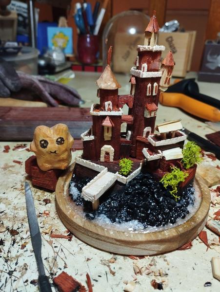 Un château miniature en bois rouge. Il y a deux tours principales et très peu de bâtimentsÀ côté Froggelio, qui fait 2 étages de haut