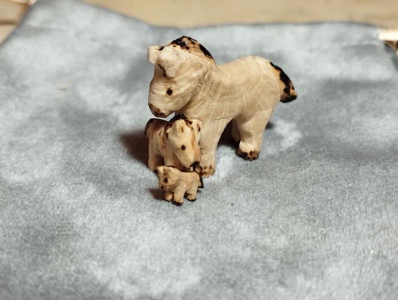 Trois mini chevaux en bois, un grand, un moyen et un petit. Le peti6est sous la tête du moyen lui-même sous la tête du grand 