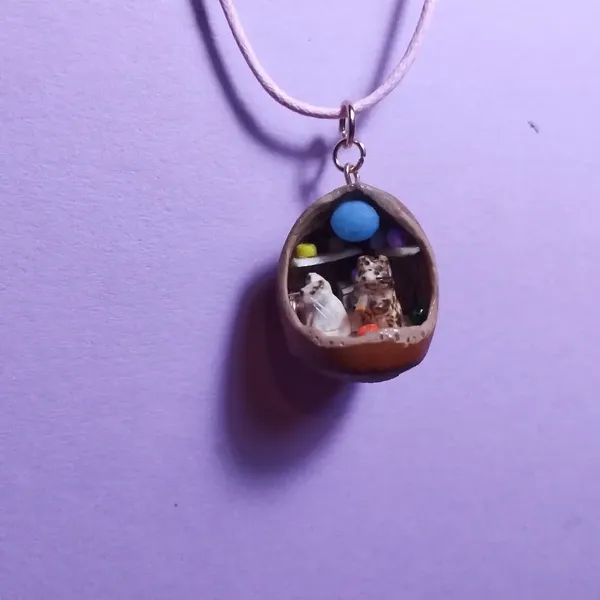 Pendentif noisette avec deux chats dedans 