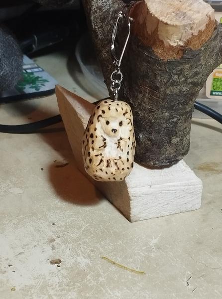 Un pendentif hérisson en bois. Les piquants sont pyrogravés