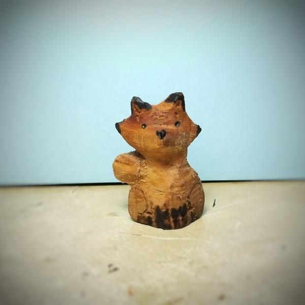 Sculpture en bois d'un renard. Les oreilles, pattes, yeux et museau sont noircies