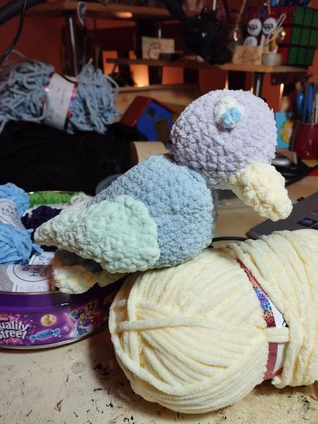 Un oiseau au crochet. Tête violette, corps bleu pâle, ailes vertes et pas de pattes 