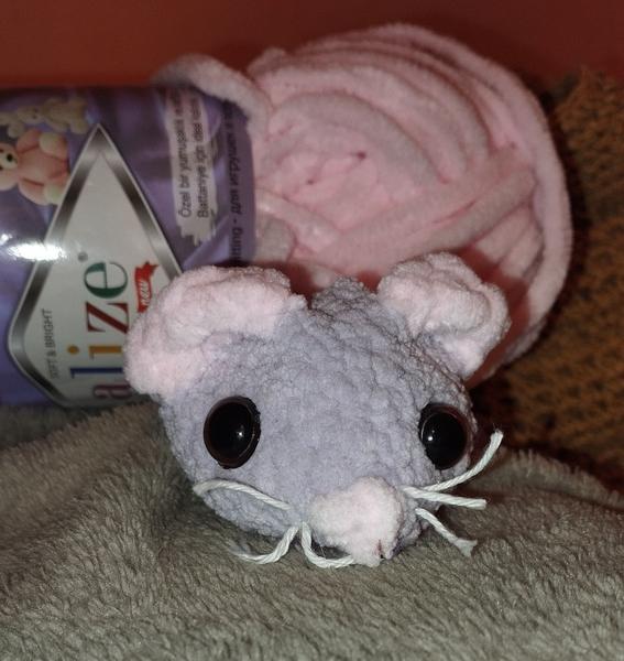 Photo d'une souris au crochet en laine chenille. Le corps est violet pale, les oreilles et le nez sont roses