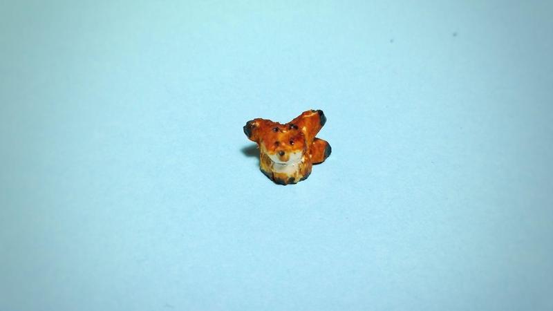 Un petit renard à trois queue en bois. Il est teint en orange