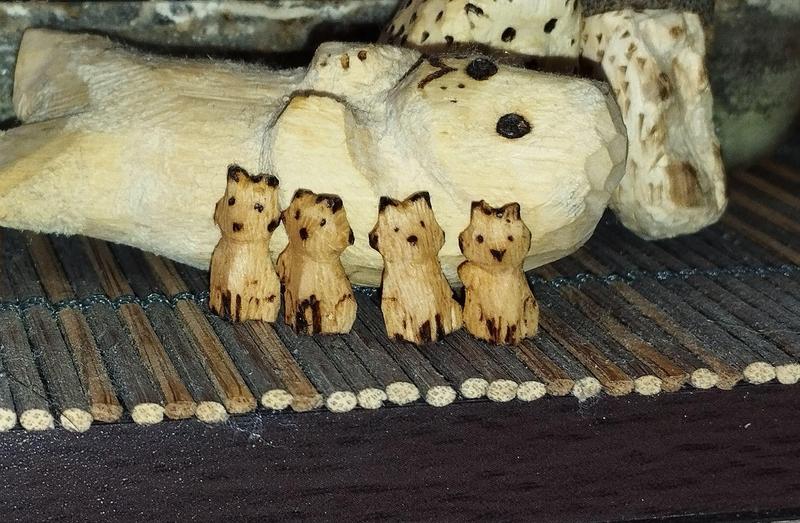 4 mini renards en bois, ils sont contre un phoque qui semble géant en comparaison
