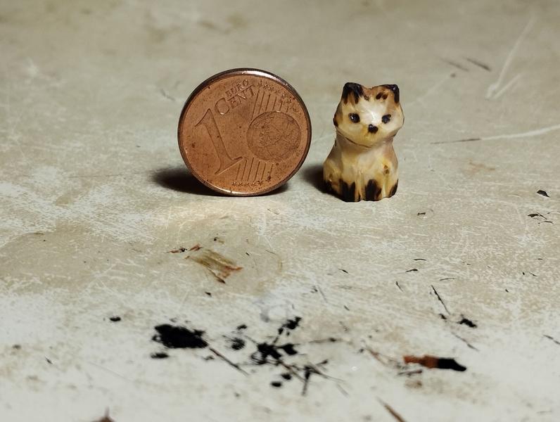 Un petit renard en bois à côté d'une pièce d'un centime 