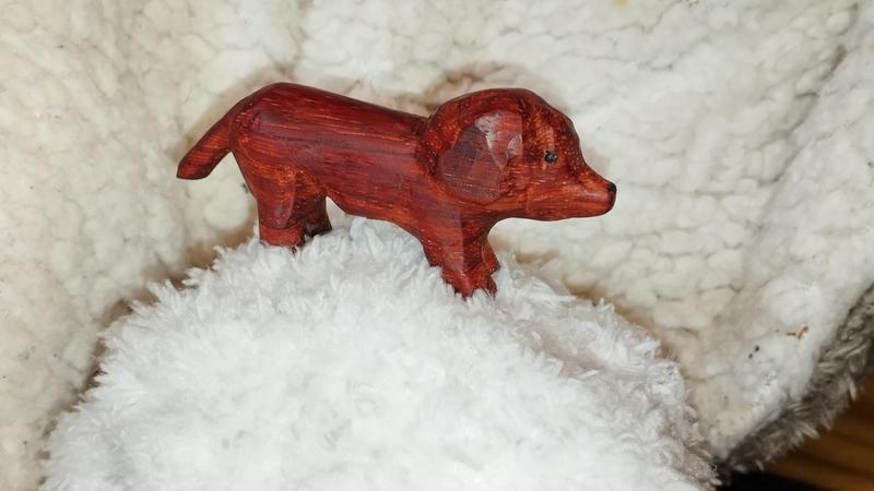 Un petit teckel sculpté dans un bois rouge