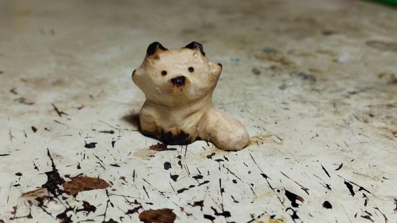 Un renard en bois, pattes oreilles et museau noircis