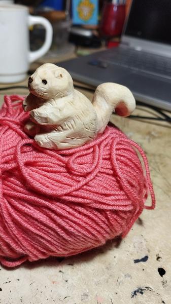 Un écureuil en bois sur une pelote de laine 