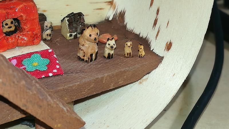 4 mini sculptures de renards en bois pyrogravé. Elles sont alignées de la plus grande à la plus petite 