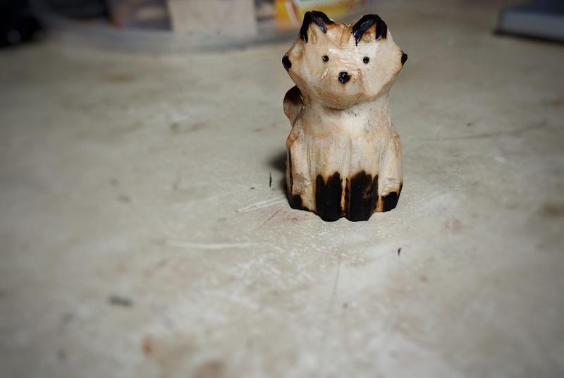 Un renard en bois. Les oreilles, yeux, truffe et les pattes sont noircies
