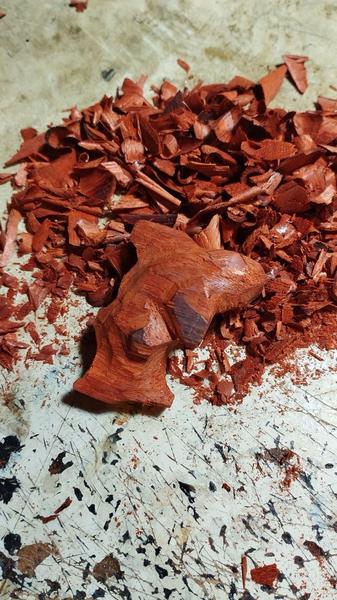 Sculpture de requin pas finie dans un bois très rouge