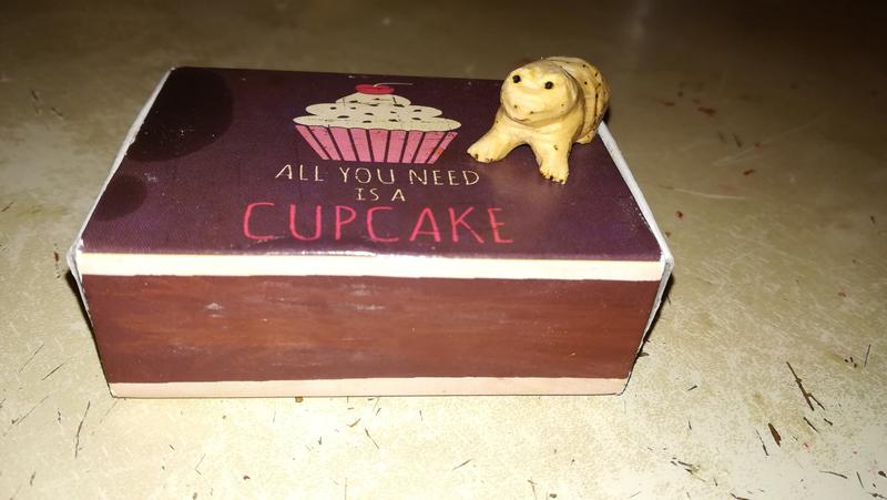 sculpture de crapaud en bois sur une boite d'allumettes